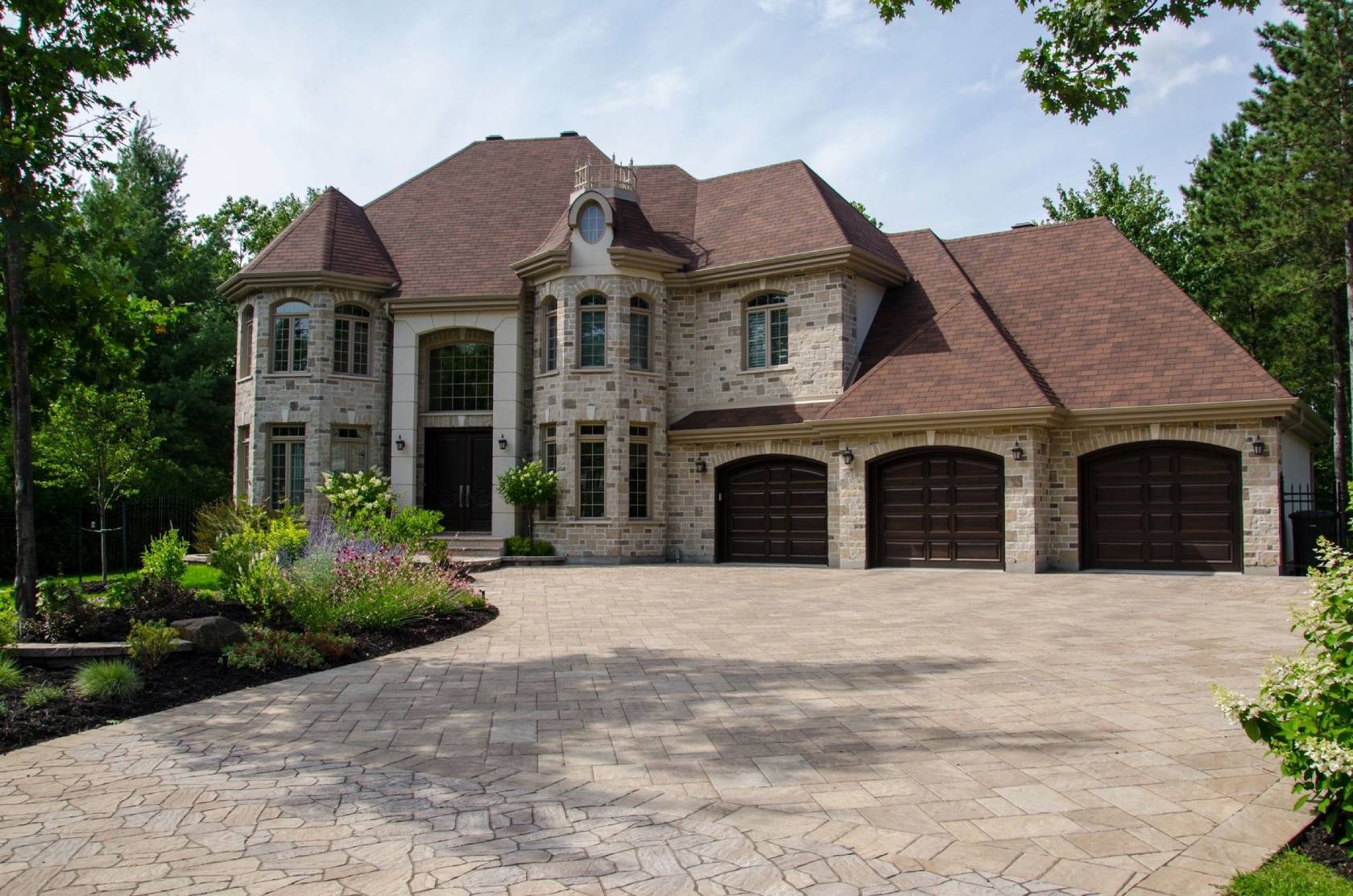 A large brick house with two garages and a driveway.